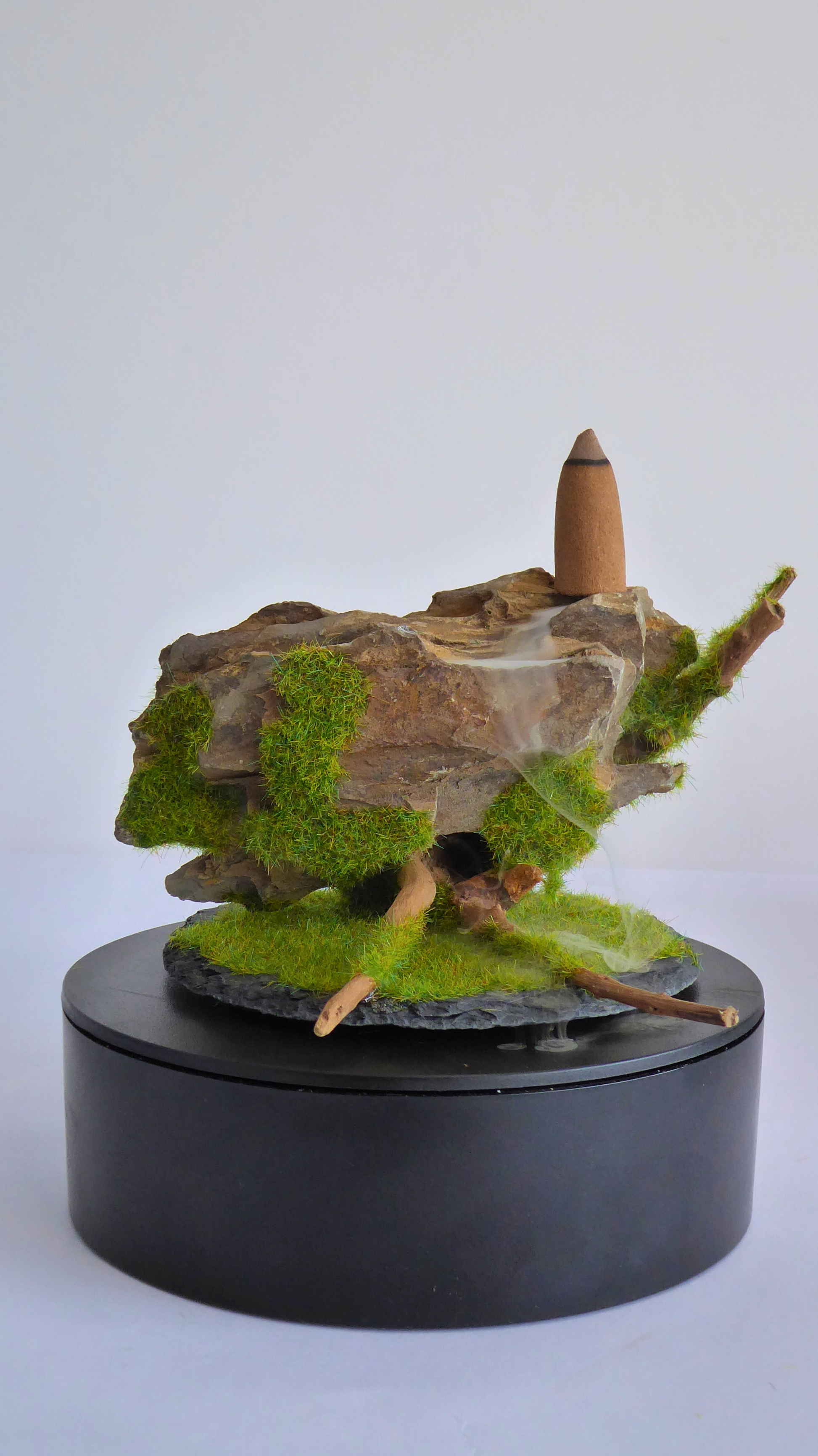 Quemador de incienso de reflujo artesanala hecho con madera, piedra y una base de pizarra, el humo fluye entre los huecos de la piedra creando un efecto de cascada hipnotiznte.