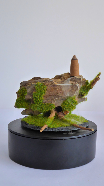 Quemador de incienso de reflujo artesanala hecho con madera, piedra y una base de pizarra, el humo fluye entre los huecos de la piedra creando un efecto de cascada hipnotiznte.